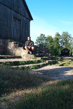 Wildrich Weltreise vor einer Holzkirche